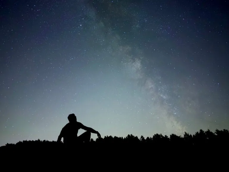 Una foto scattata con iPhone 18 Pro in modalità Notte che mostra la silhouette di una persona davanti a un cielo stellato
