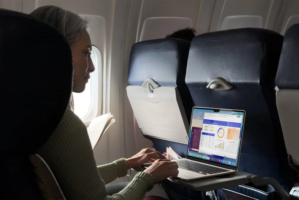 Una persona lavora su un MacBook Air durante un volo.